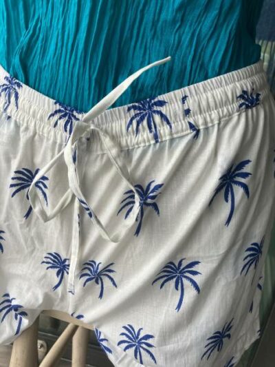 Short en coton blanc avec motifs de palmiers bleus.