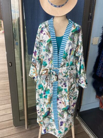 Kimono long avec bordure rayée bleue et motifs d'oiseaux sur fond blanc. Présenté à la boutique La Reine Outremer à Roscoff.